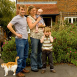 Family and Cat ourside their home